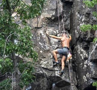 What does the term 'belay' mean in rock climbing?
