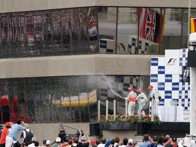 Who famously sprayed champagne for the first time on the F1 podium?