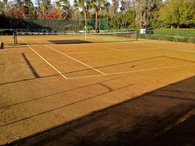Which Grand Slam tournament is known for its red clay courts?