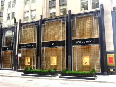 Which retailer is known for its luxury designer brands and high-end fashion?