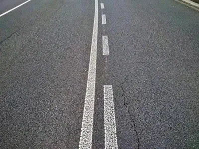 What does a solid white line on the road indicate?