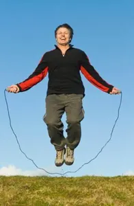 Should the arms stay close to the body while jump roping?
