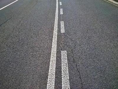 What does a solid white line indicate on the road?