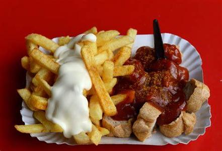 “Currywurst is a fast food dish of German origin consisting of steamed, then fried pork sausage typically cut into slices and seasoned with curry ketchup, a sauce based on spiced ketchup or tomato paste, itself topped with curry powder, or a ready-made ketchup seasoned with curry and other spices. The dish is often served with French fries.”  Wikipedia.