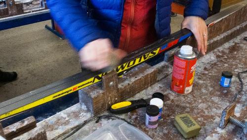 What is the main purpose of waxing skis?