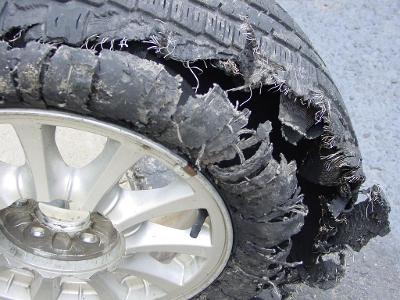 What should you do if you experience a tire blowout while driving?