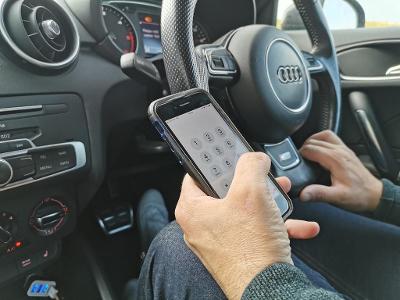 When is it illegal to use a handheld device while driving?