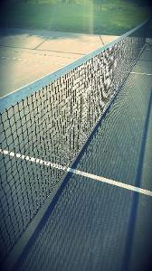 Which game is played on a court divided into front and back areas with a net in the middle?