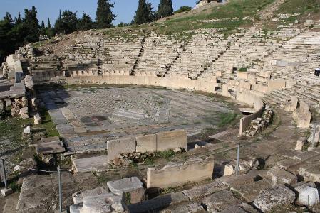 What was the name of the structure used as the backdrop for performances in ancient Greek theater?