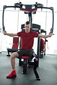 How should you adjust your arms on an elliptical machine to engage different muscles?