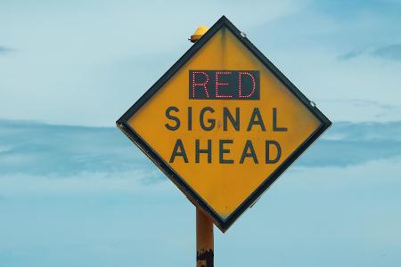 What does a red 'X' over a lane signal indicate on a highway?