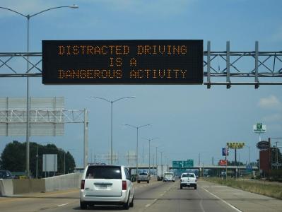 Which of the following is a common warning sign of a distracted driver?
