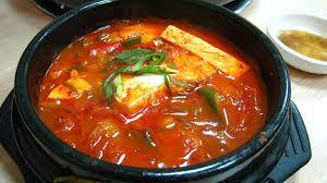 "Jjigae is a Korean dish similar to a Western stew. There are many varieties; it is typically made with meat, seafood or vegetables in a broth seasoned with gochujang, doenjang, ganjang or saeujeot. Jjigae is usually served in a communal dish and boiling hot."