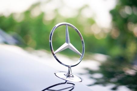 Which luxury car brand is known for its iconic three-pointed star logo?