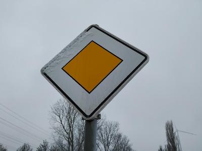 What does a yellow diamond-shaped sign indicate?