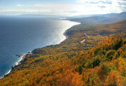 Which country is home to the famous Cabot Trail, a scenic biking route along the coast?